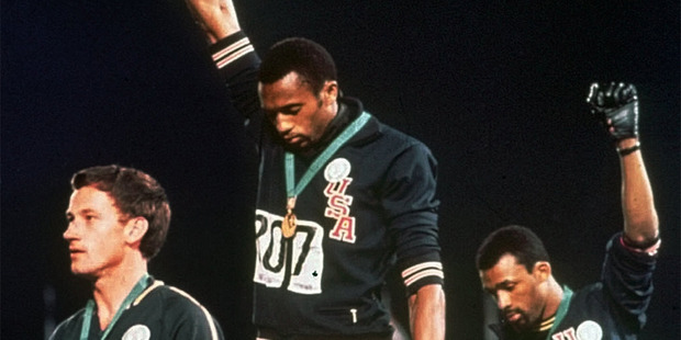 Peter Norman, left, stands during the US national anthem as American sprinters Tommie Smith and John Carlos extend their gloved hands skyward in racial protest. Photo / AP