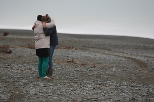 Family and friends of the missing whitebaiter comfort each other. Photo / Ashburton Guardian