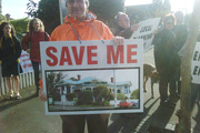 About a dozen people waved placards outside the villa in Herne Bay. Photo / Bernard Orsman