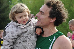 Dougal Thorburn carries his daughter, Audrey, after setting a world record for the fastest 10km run while pushing a pram. Photo / Otago Daily Times