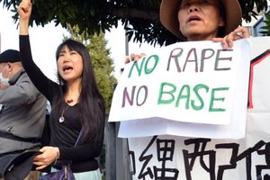 Civic group members shout slogans and hold placards as they attend a protest over the alleged rape of a local woman by two US servicemen in Okinawa. Photo / AFP