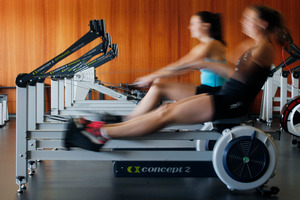Lucy Spoors (foreground) and Kelsey Bevan work out on the erg machines at Lake Karapiro. Photo / Christine Cornege