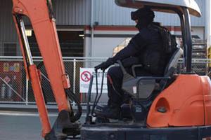 Police used a digger to smash into the Red Devils HQ in Nelson. Photo / Supplied