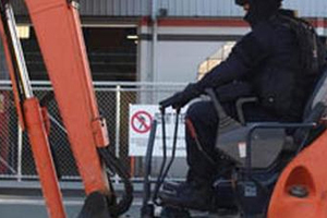 Police used a digger to smash into the Red Devils HQ in Nelson. Photo / Supplied