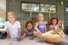 Amber Gleeson, Nevaeh-Lee Matiu,3, Isabella Troughton,4, and Sangreal Ekins, 3, of Maungaarangi Kindergarten with a gourd that was smashed by vandals. Photo / Joel Ford