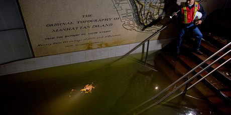 Joseph Leader, Metropolitan Tranportation Authority Vice President and Chief Maintenance Officer, shines a flashlight on standing water inside the South Ferry 1 train station in New York. Photo / AP