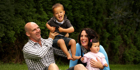 Andrew Fitzgerald at home yesterday with son Johnny, 2, and his wife, Emma, holding 8-month-old Livvy. Photo / Alan Gibson