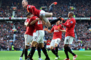 Manchester United's Robin van Persie, bottom center, is congratulated by teammates after scoring against Arsenal during the English Premier League soccer match at Old Trafford. Photo / Getty Images.