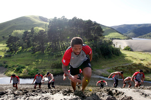 Manu Vatuvei leads players up a sand dune at Bethells yesterday. Photo / Michael Craig