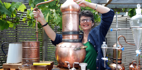 Jill Mulvaney adjusts the copper still in her garden. Photo / Doug Sherring