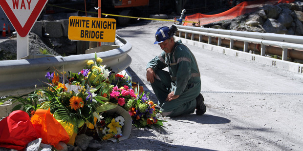 A miner laying down flowers at the White Knight Bridge near the entrance to the Pike River mine. Photo / NZPA