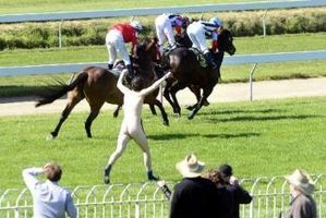 Chased by security and police, the man cleared the track and jumped a fence before being taken into custody. Photo / Otago Daily Times