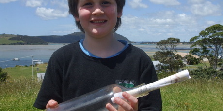 Shayde Flood, 5, with the bottle and note his father, Geoff, found on Ninety Mile Beach. The note came with a picture of the Strathnaver and was cast into the sea by Herbert Hillbrick. Photo / Supplied