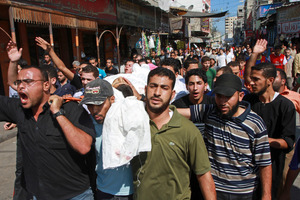 Palestinians carry the body of a militant killed during an Israeli air strike. Photo / AP