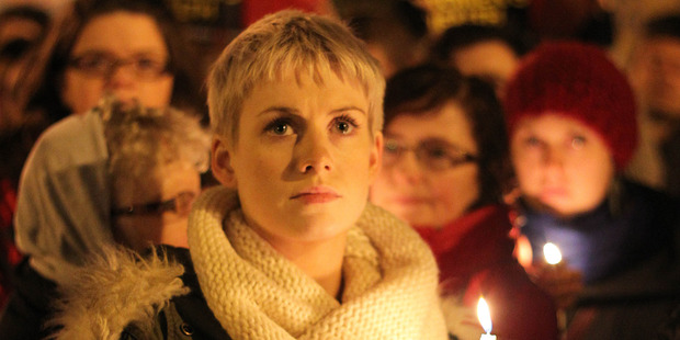 A protester holds a candle during a march in Dublin. Photo / AP
