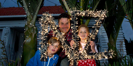 Justin Newcombe with his Christmas tree lights project, accompanied by his children, Jasper and Grace. Photo / Sarah Ivey