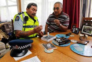 Bill Taua shows James Ranginui how the kit works during the police visit to the Fairfield area. Photo / Christine Cornege