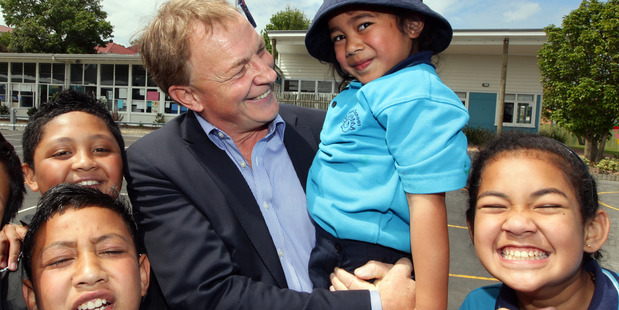 Phil Goff, holding 5-year-old Daphne Lamatia at Hay Park Primary School, is almost as busy as when he was Leader of the Opposition, but his life is far more relaxed. Photo / Doug Sherring