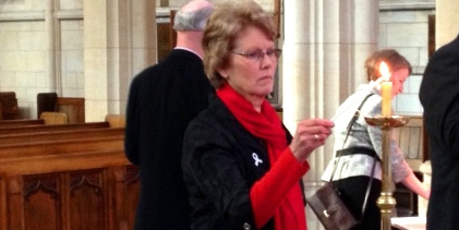White Ribbon supporter Lesley Elliott lights a candle at St Paul's Cathedral yesterday. Photo / Shawn McAvinue.