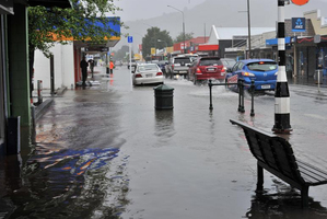 Traffic displaces water, making wake waves on flooded Gordon Rd on Saturday. Photos / Peter McIntosh and Jane Dawber