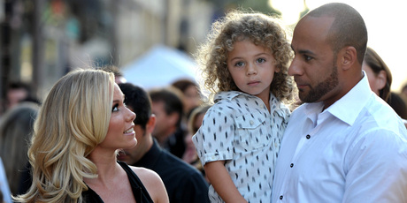 Kendra Wilkinson, left, son Hank Baskett IV, and husband Hank Baskett. Photo/AP
