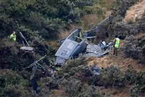 Air force investigators at work around the wreckage the 3 Squadron Iroquois helicopter which crashed in steep hill country at Pukerua Bay. Photo / Mark Mitchell