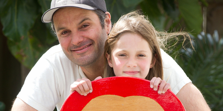 Justin Newcombe with his daughter and their DIY surfboard. Photo / Richard Robinson