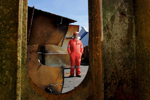 Frank Leckey, salvage master for Resolve Wreckage and Fire, stands amongst the hundreds on tons of steel removed from the ship, Rena. Photo / APN