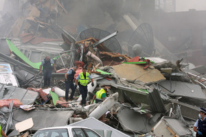 Police search through rubble of the collapsed CTV building looking for survivors, shortly after the devastating quake. Photo / Geoff Sloan