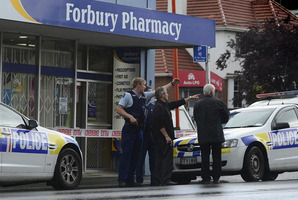 Dunedin police officers indicate the direction in which a man fled after the alleged aggravated robbery. Photo / Peter McIntosh