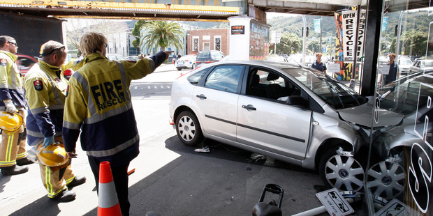 Emergency services were called after this Ford Focus crashed into the Rust Ave Barbers yesterday, which saw a hairdresser flee for her life as the car smashed through the front window. Photo / JOHN STONE