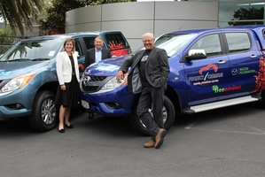 Bridget Abernethy, left, Andrew Clearwater and Project Crimson trustee Ruud Kleinpaste admire the new utes Mazda has given the trust. Photo / Supplied