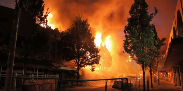 Fire personnel try to douse flames of a fire in a building on High Street in the Red Zone in Christchurch. Photo / Mark McCarthy