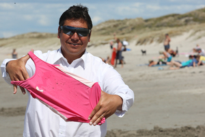 Expelled Brendan Horan displaying his daughter's oil-stained swimsuit. Photo / Mark McKeown