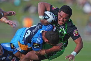 Warriors' Konrad Hurrell is wrapped up by Titans' Brenton Lawrence in yesterday's NRL trial match at North Harbour Stadium. Photo / Getty Images