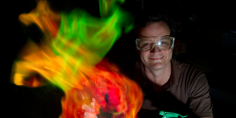 Peter Stewart, the head chemistry teacher at Papatoetoe High School, obliges the photographer with a multi-hued, photogenic fireball. Photo / Sarah Ivey
