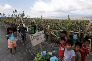 Residents affected by typhoon Bopha beg for aid from passing motorists along a highway in southern Philippines. Photo / AP