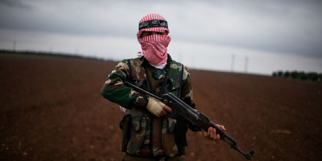 A Free Syrian Army fighter takes position close to a military base, near Azaz, Syria. Photo / AP