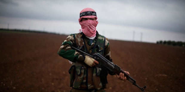 A Free Syrian Army fighter takes position close to a military base, near Azaz, Syria. Photo / AP