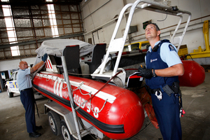 Onerahi community Constables Spence Penney (left) and Aaron Furze examine the boat found dumped on the side of the road. Photo / Michael Cunningham
