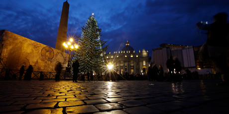The cut-price Christmas tree is lit in St. Peter's square at the Vatican.