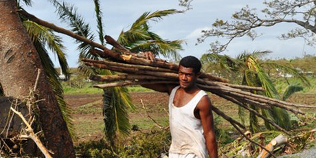 Cyclone Evan destroyed many homes in Nadi while in Lautoka a resident stocks up on newly created firewood. Photo / Fiji Ministry of Information