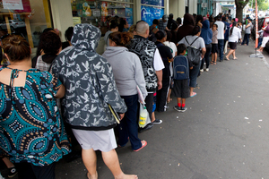 The queue snakes out the door and down the street as City Mission clients pick up some Christmas cheer. Photo / Brett Phibbs