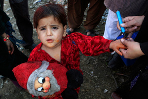 A Pakistani health worker marks an infant after immunization with anti-polio drops in slums of Lahore, Pakistan. Photo / AP