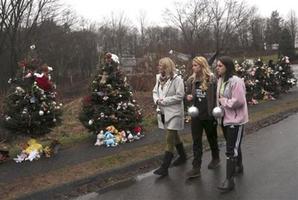 Mourners carry ornaments to decorate the Christmas trees at one of the makeshift memorials for the Sandy Hook Elementary School. Photo / AP