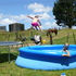 Olivia Laird flies into the pool on a hot summer's day at the farm in Hikurangi. Her sister Brooke is waiting for the splash. Photo / Sue Churton 