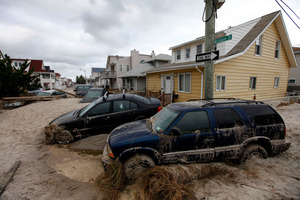 Dylan Smith used his surfboard to ferry many people to safety during the late October superstorm. Photo / AP