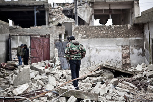 Free Syrian Army fighters walk amid the ruins of a village. Photo / AP