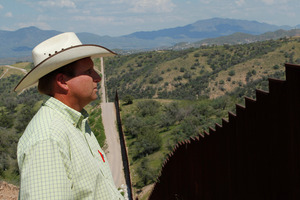 Rancher Dan Bell, who owns a 35,000-acre cattle ranch along the border between the United States and Mexico, looks at the imposing border fence, in Nogales, Arizona. Photo / AP