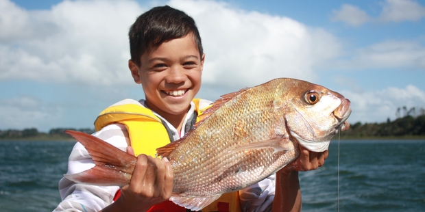 The perfect combination - a boy and a freshly caught fish. Photo / Russell Baker
